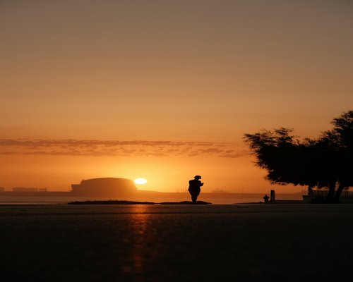 Person walking outdoors during golden hour sunrise